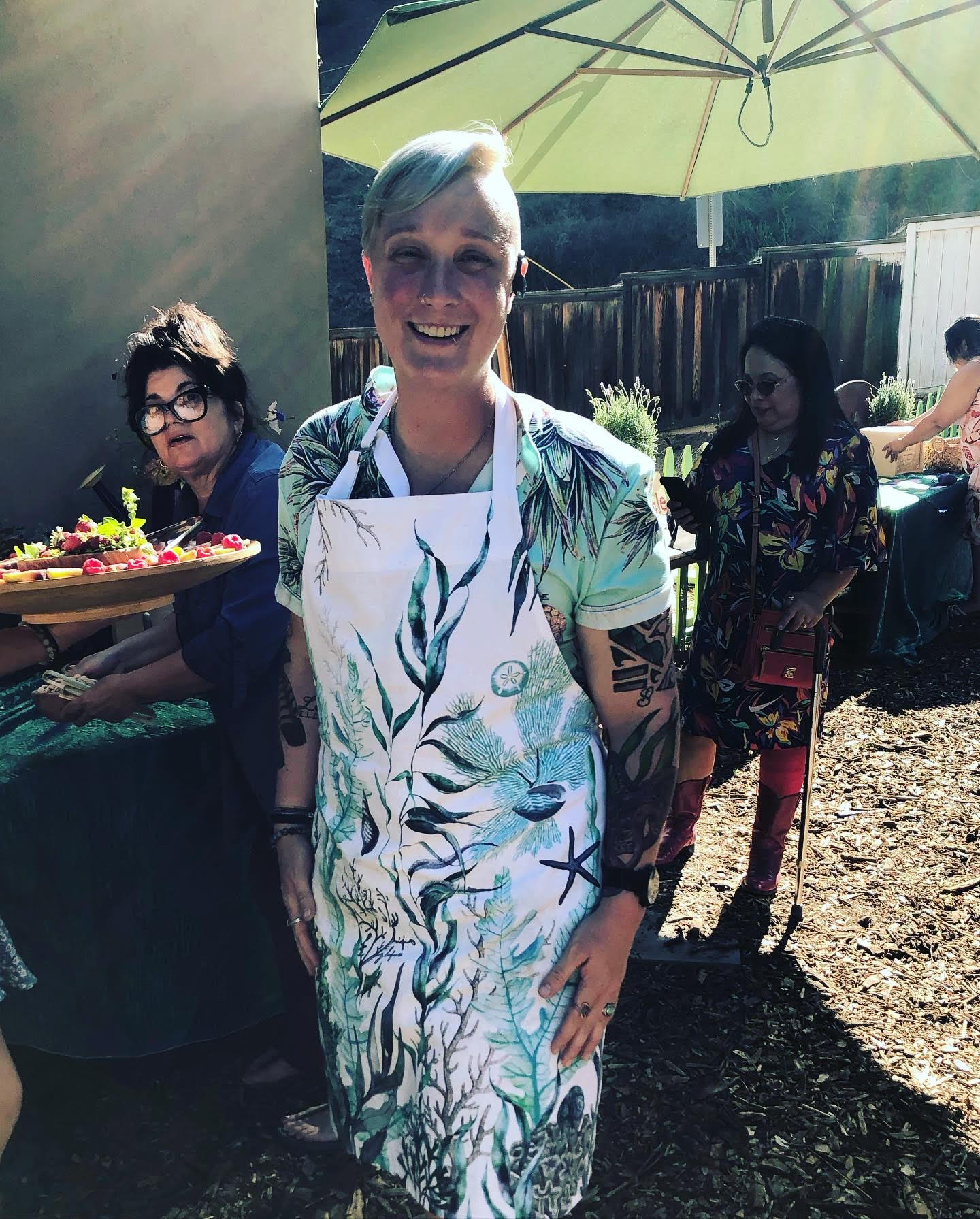 Jules in a chef apron plating a seaweed course